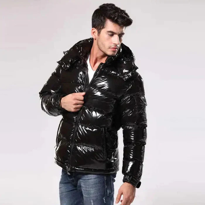Junger Mann in glänzender schwarzer Daunenjacke, modisch, warm, Winterbekleidung, lässiger Stil, isolierter Hintergrund.