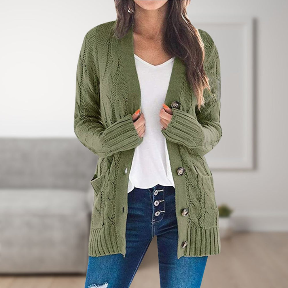 Frau trägt olivgrüne Strickjacke mit Zopfmuster, weiße Bluse und blaue Jeans. Modetrend, Damenmode, gemütlicher Look, Herbstoutfit.