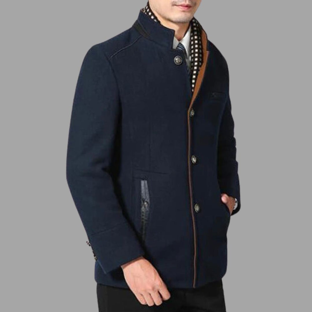 Mann in eleganter, dunkelblauer Herrenjacke mit Stehkragen und Knopfleiste, modisch kombiniert mit kariertem Schal. Ideal für Herbstmode.