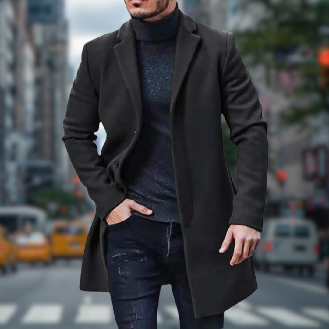 Ein Mann in einem eleganten schwarzen Mantel und Rollkragenpullover geht auf einer belebten Stadtstraße. Hintergrund mit unscharfen Taxis und Gebäuden.