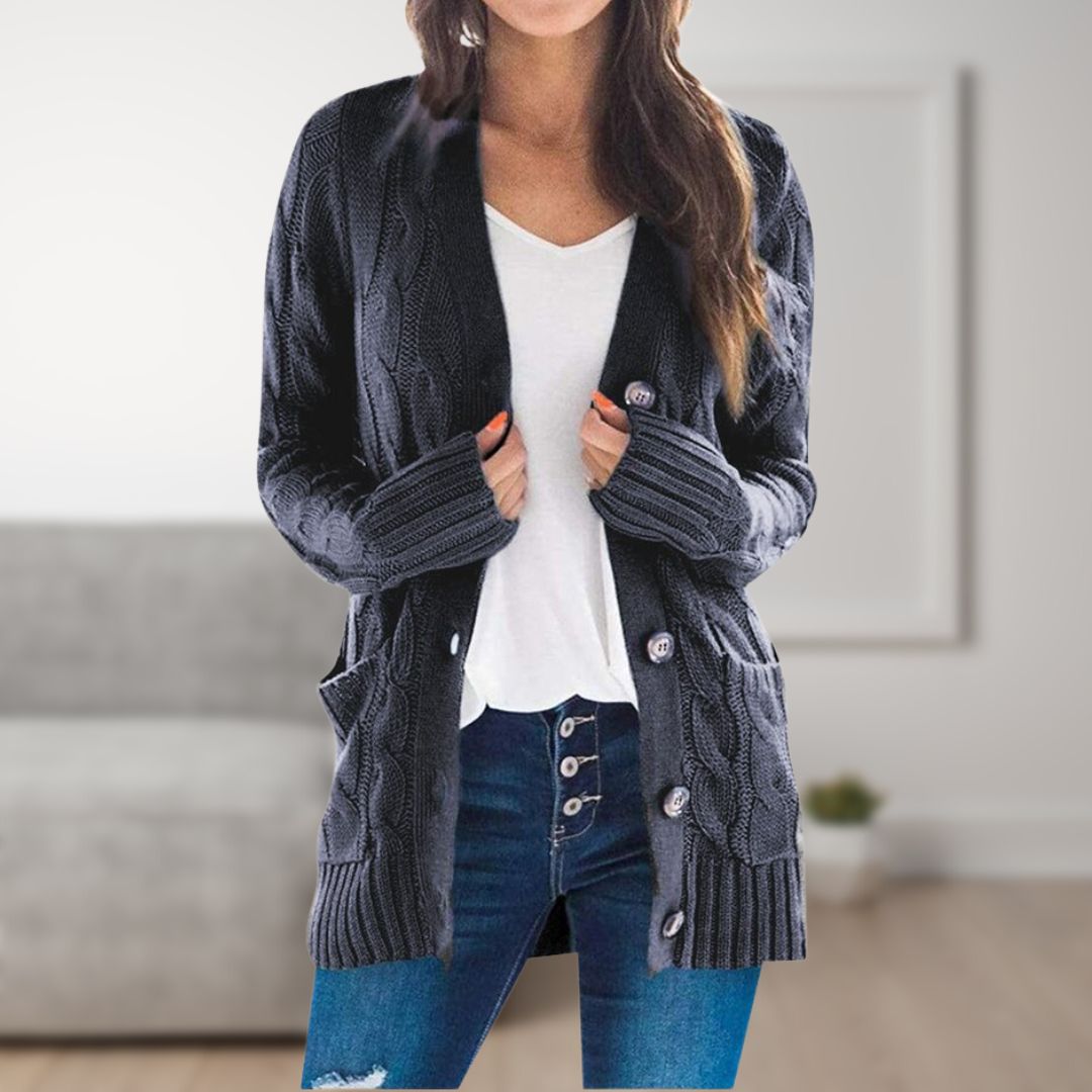 Dunkelblauer Strick-Cardigan für Damen, lässig offen getragen, kombiniert mit weißem T-Shirt und Jeans, im modernen Wohnzimmer.