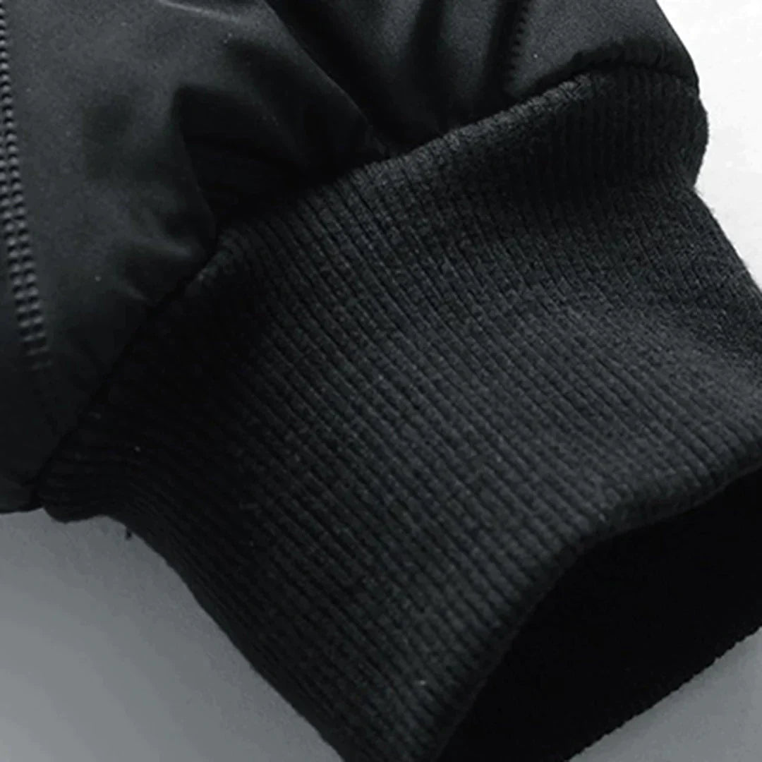 Schwarzer Ärmel einer Winterjacke mit geripptem Bündchen, Nahaufnahme. Hochwertige Outdoor-Bekleidung, warm und wetterfest.