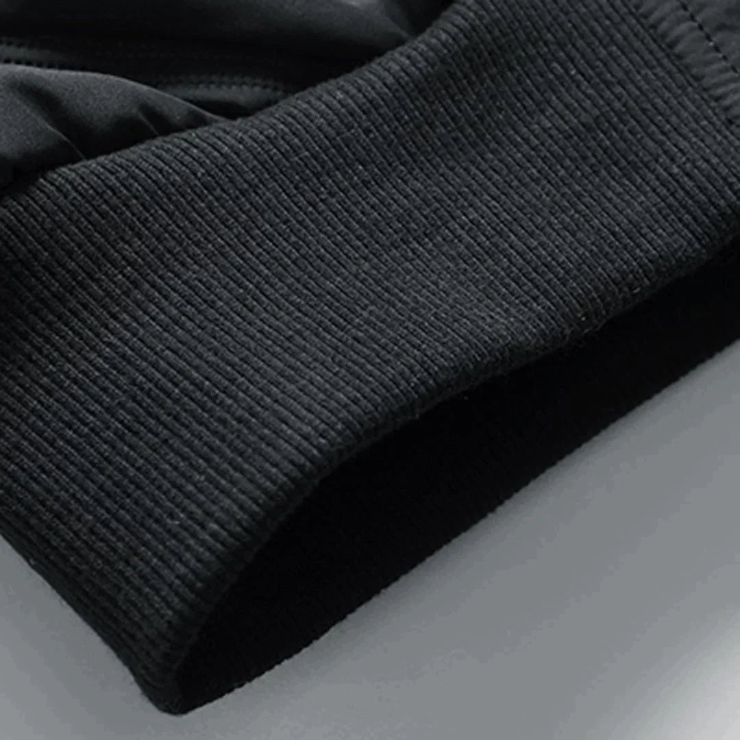 Schwarzer, gerippter Ärmelabschluss eines Sport-Sweatshirts aus Baumwollmischung, Nahaufnahme. Ideal für Fitness, Laufen, Outdoor-Aktivitäten.