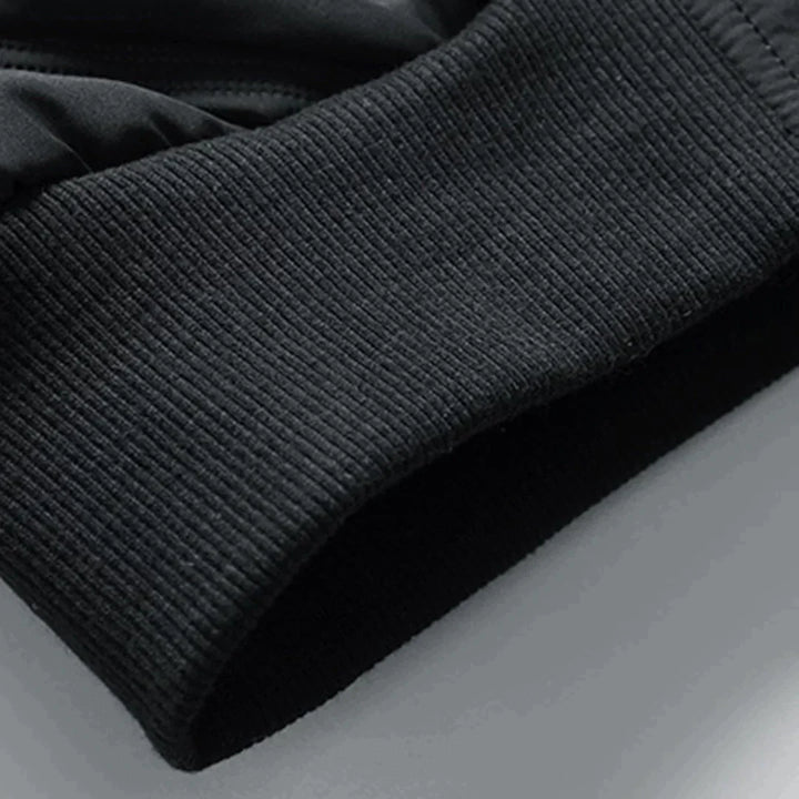 Schwarzer, gerippter Ärmelabschluss eines Sport-Sweatshirts aus Baumwollmischung, Nahaufnahme. Ideal für Fitness, Laufen, Outdoor-Aktivitäten.