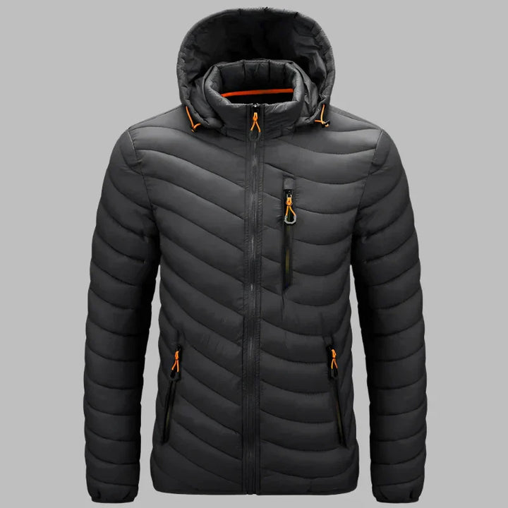 Dunkelgraue Steppjacke mit Kapuze, Reißverschlusstaschen und orangefarbenen Akzenten. Winterjacke für Herren, warm und wasserabweisend.