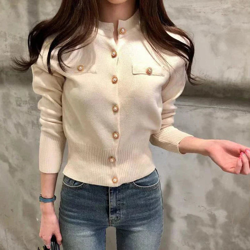 Damen Strickjacke in Creme mit Knopfleiste und Brusttaschen, kombiniert mit blauer Jeans. Modetrend, elegante Freizeitkleidung, stilvoller Look.