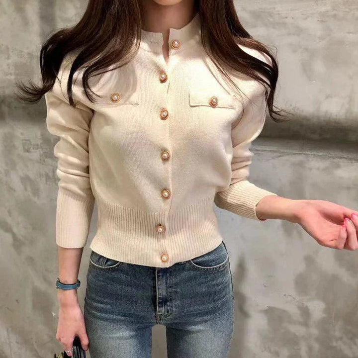 Damen Strickjacke in Creme mit Knopfleiste und Brusttaschen, kombiniert mit blauer Jeans. Modetrend, elegante Freizeitkleidung, stilvoller Look.