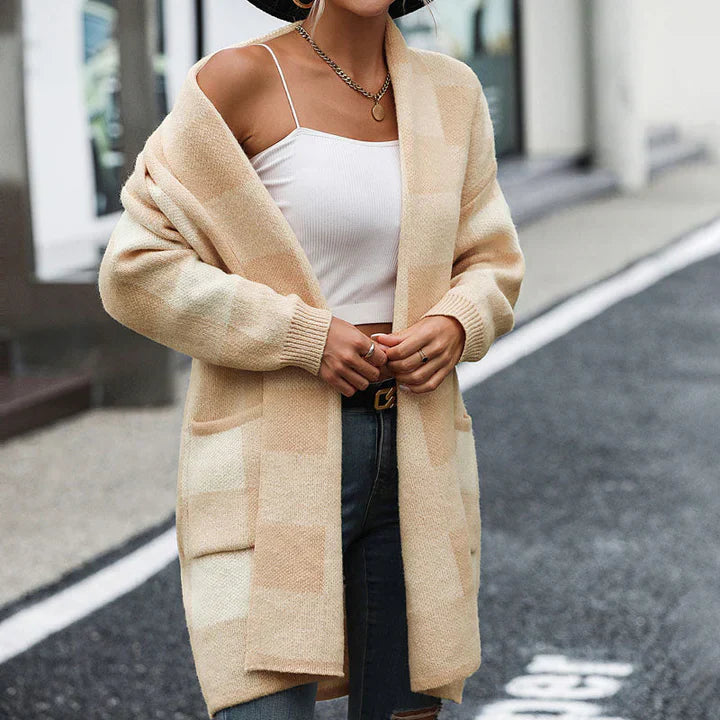 Frau in beigem Karo-Cardigan und weißem Top auf Straße. Modetrend, Herbstmode, lässiger Stil, Damenbekleidung, Streetwear.