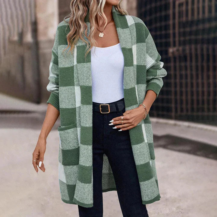 Frau trägt grün-weiß karierten Cardigan, weißes Top und schwarze Hose. Modetrend Herbst, lässiger Look, stilvolle Damenbekleidung.