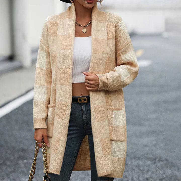 Dame in kariertem Strickmantel, weißem Top und Jeans auf Straße. Modetrend Herbst, lässiger Look, stilvolle Damenmode, beiger Mantel.