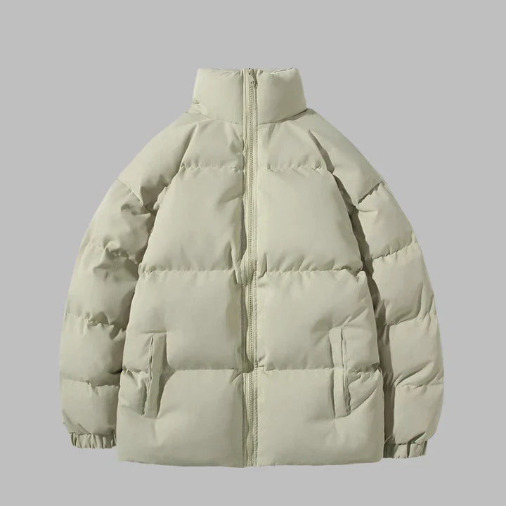 Beige Daunenjacke mit Reißverschluss, Stehkragen und Seitentaschen. Wintermode, warme Outdoor-Bekleidung, stilvolle Pufferjacke für kalte Tage.