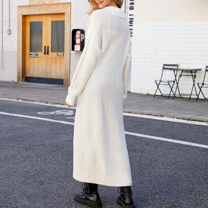 Frau in langem, weißem Strickkleid und schwarzen Stiefeln auf städtischer Straße. Modetrend Herbst/Winter, lässiger Stil, Outdoor-Fashion.