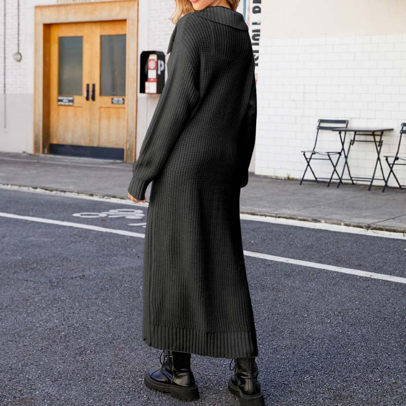 Frau in langem, schwarzem Strickkleid und Stiefeln steht auf städtischer Straße. Modetrend, Herbstmode, urbaner Stil, lässiges Outfit.