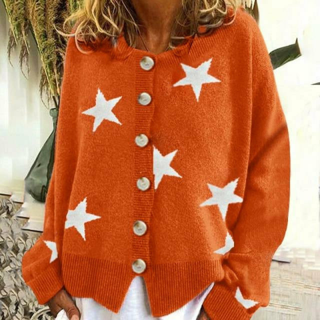 Orangefarbener Strickpullover mit weißen Sternen und großen Knöpfen, getragen von einer Frau. Modetrend, Herbstmode, Damenbekleidung.