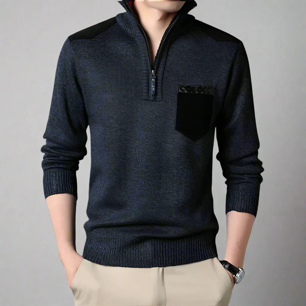 Dunkelblauer Herrenpullover mit Reißverschluss und Brusttasche, kombiniert mit beigen Hosen. Stilvolle Herrenmode, ideal für Herbst und Winter.